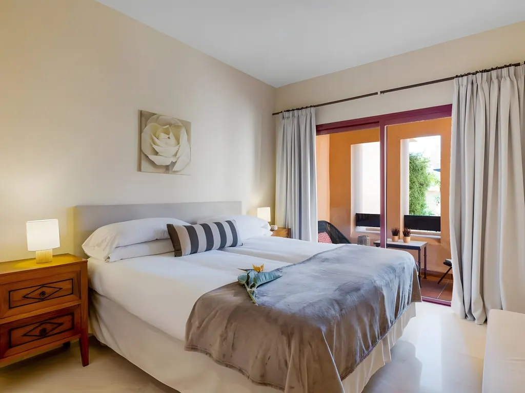 Apartment Bahía Alcántara Habitación moderna con cama doble, mesitas de noche y puertas al balcón