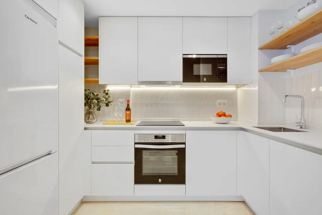 Castillo Santa Clara Cocina moderna blanca con electrodomésticos empotrados e iluminación LED bajo muebles