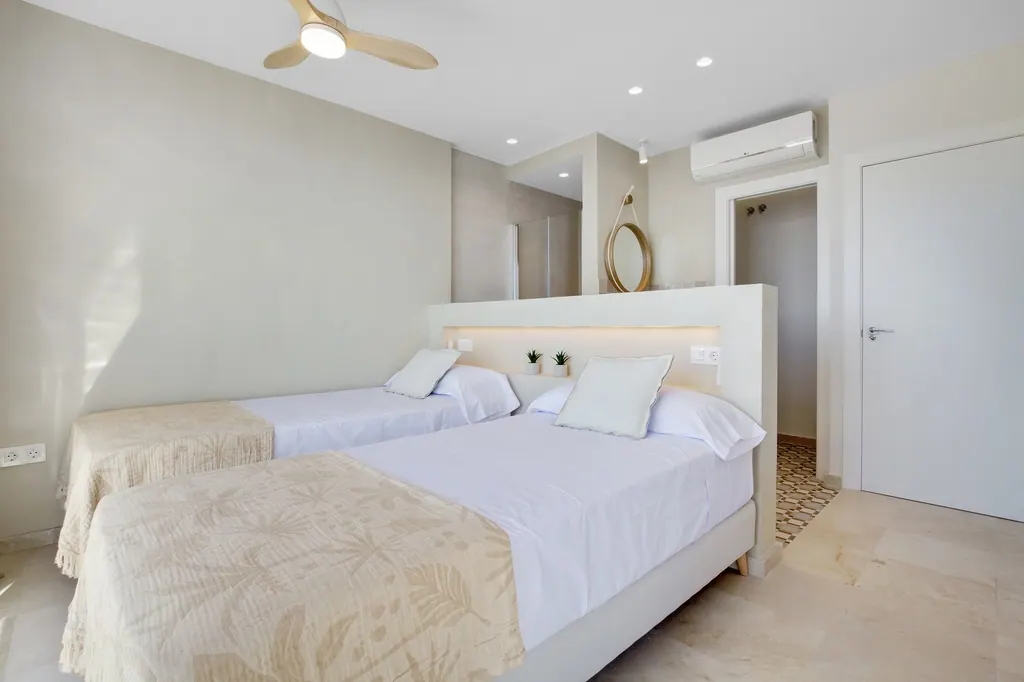 Castillo Santa Clara Habitación moderna con dos camas individuales blancas y decoración minimalista beige