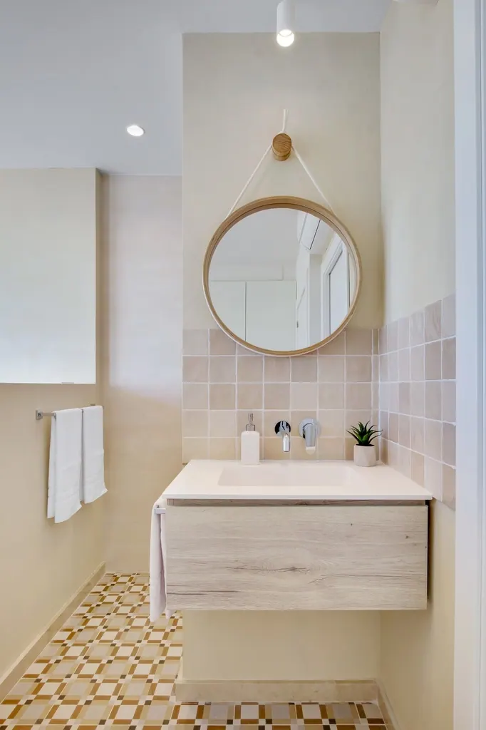 Castillo Santa Clara Baño moderno minimalista con espejo redondo colgante y lavabo flotante de madera