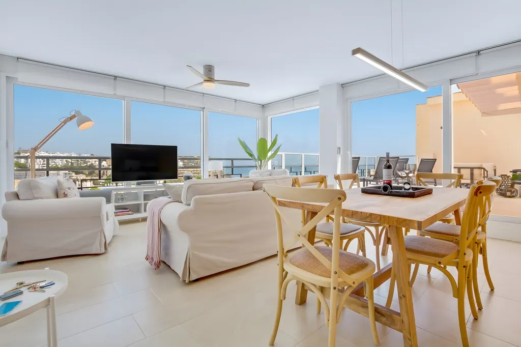 Penthouse la Carihuela Salón comedor moderno con vistas al mar y decoración minimalista blanca