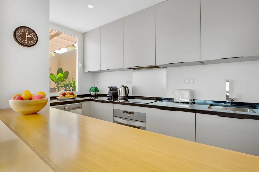 Penthouse la Carihuela Cocina moderna minimalista con encimera negra y muebles grises claros