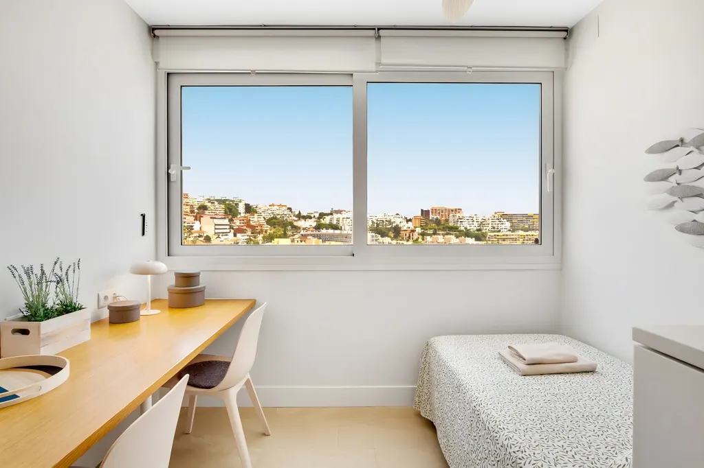 Penthouse la Carihuela Habitación minimalista con escritorio de madera y ventana con vistas urbanas
