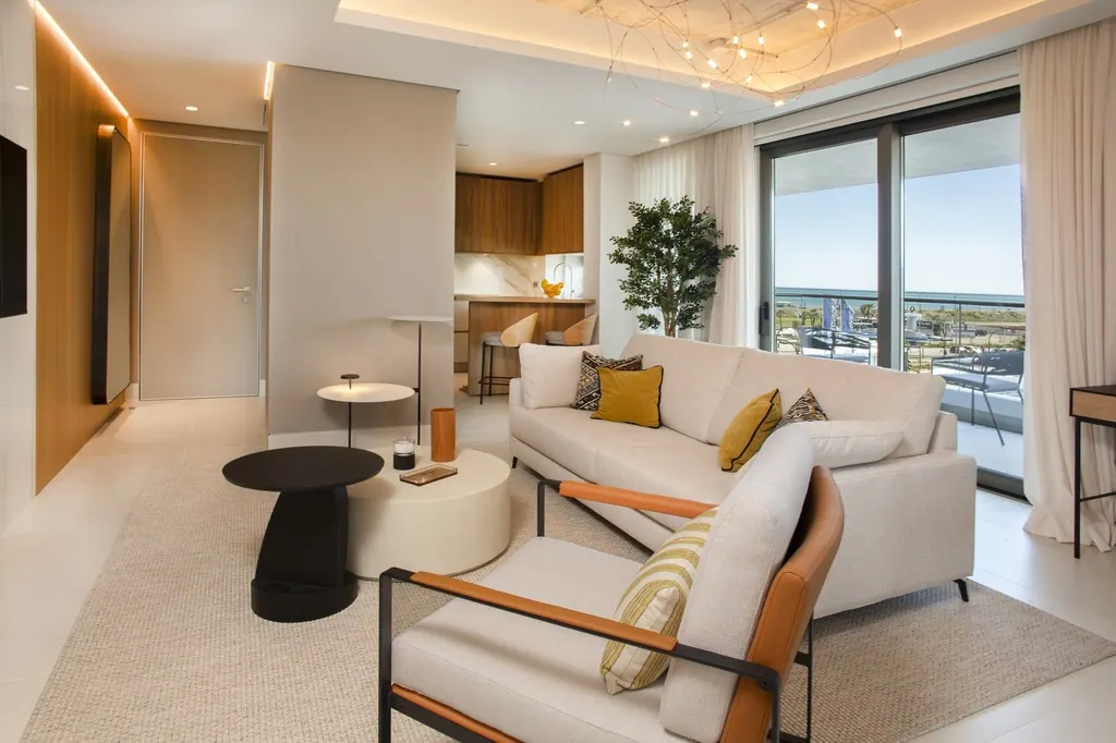 Sala de estar moderna con sofá beige y vistas al mar