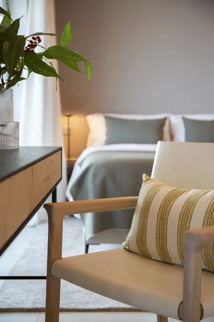 Dormitorio moderno con sillón beige y decoración minimalista elegante