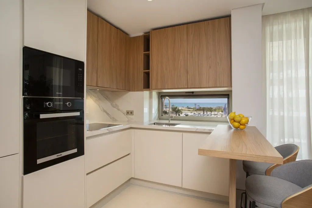 Cocina moderna con muebles de madera y encimera blanca minimalista