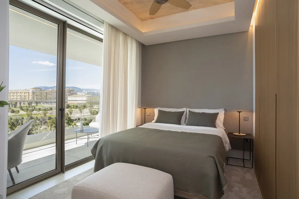 Dormitorio moderno con balcón y vistas a la ciudad