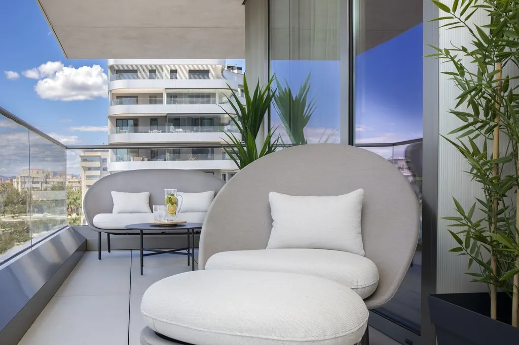 Terraza moderna con muebles blancos y vistas a edificios urbanos