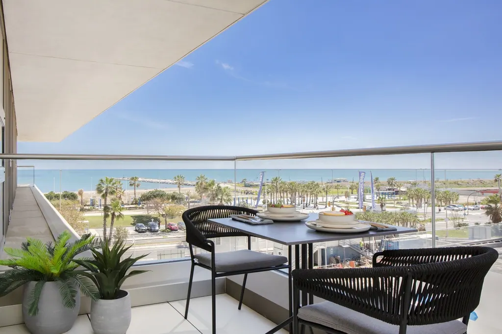 Terraza moderna con vistas al mar y palmeras en residencial costero