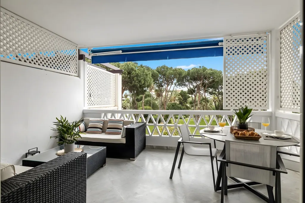 Terraza moderna con muebles de ratán y vistas al jardín