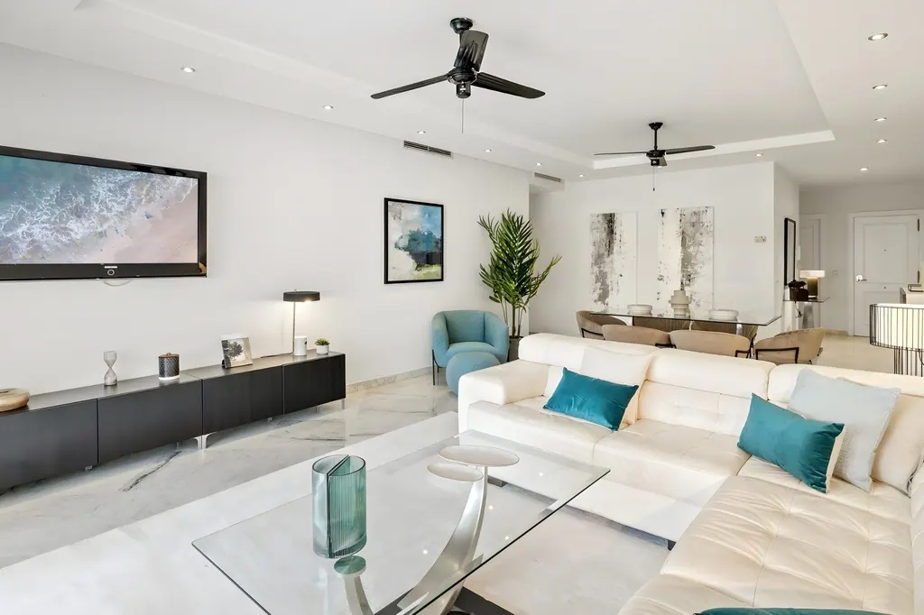 Sala de estar moderna con sofá blanco y acentos azules turquesa