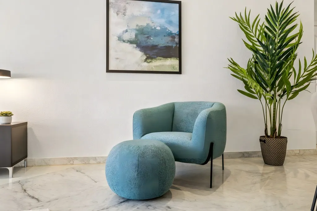 Sala de estar moderna con sillón azul turquesa y planta decorativa